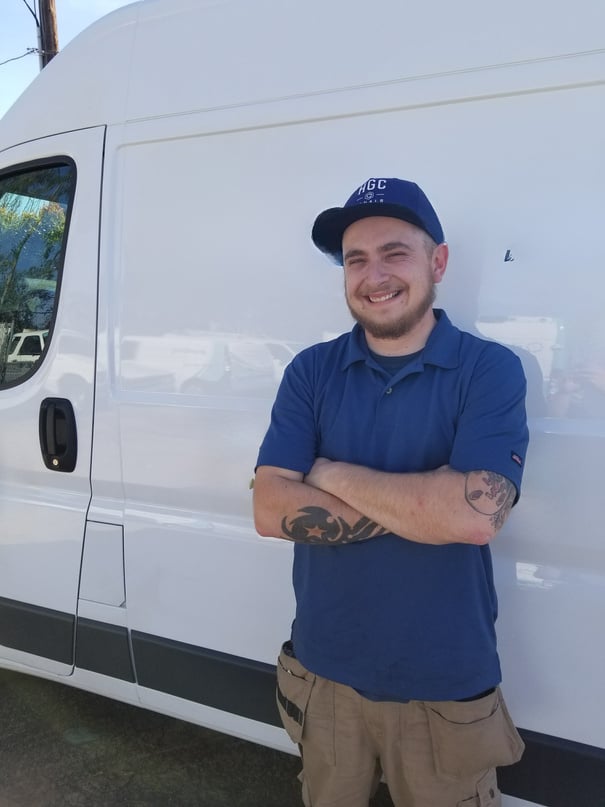 a person in a blue shirt standing in front of a white van